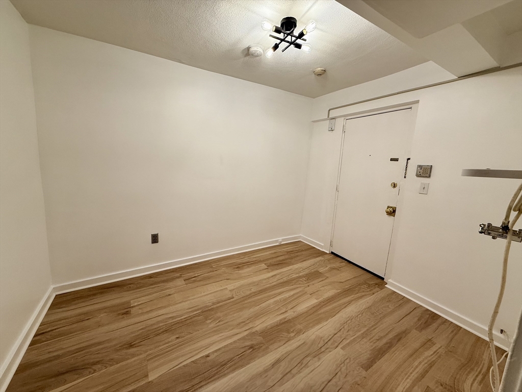 28 Ransom Road, Unit 12AB Boston, MA 02135 - Photo 15 of 17 a view of a room with wooden floor and cabinet