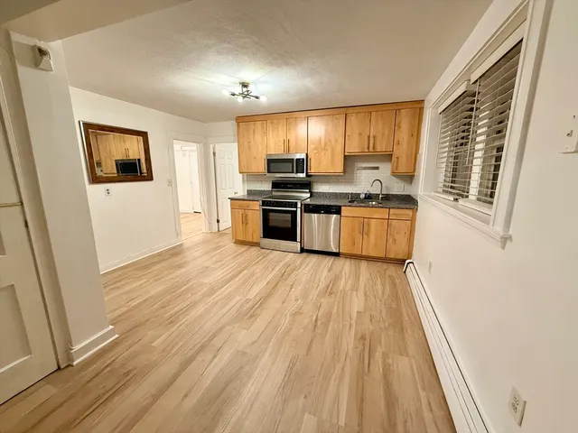 a kitchen with a sink wooden floor and a window
