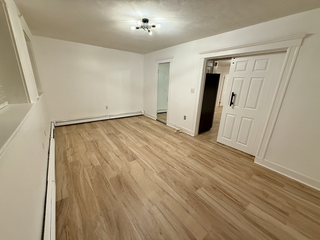 28 Ransom Road, Unit 12AB Boston, MA 02135 - Photo 8 of 17 wooden floor in an empty room with a window