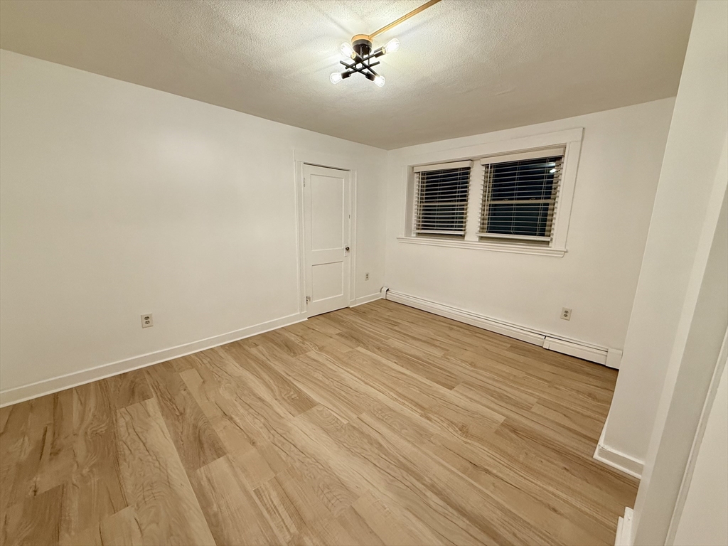 28 Ransom Road, Unit 12AB Boston, MA 02135 - Photo 9 of 17 a view of empty room with wooden floor and fan