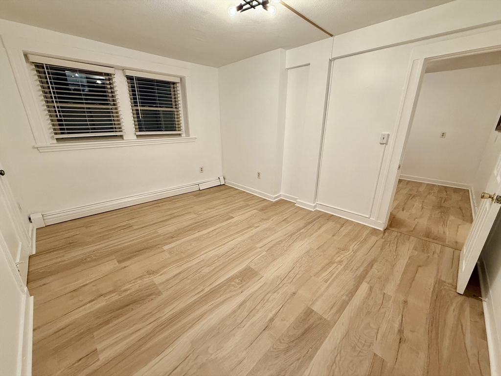 28 Ransom Road, Unit 12AB Boston, MA 02135 - Photo 10 of 17 a view of an empty room with wooden floor and a window