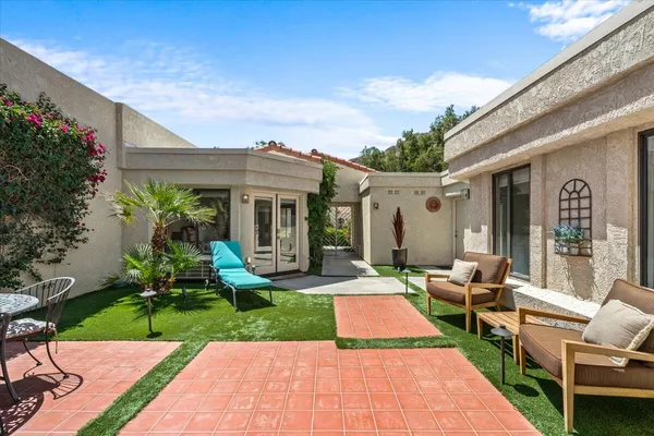 a view of a house with backyard porch and sitting area