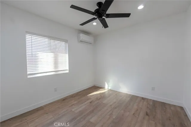 an empty room with a window and a fan