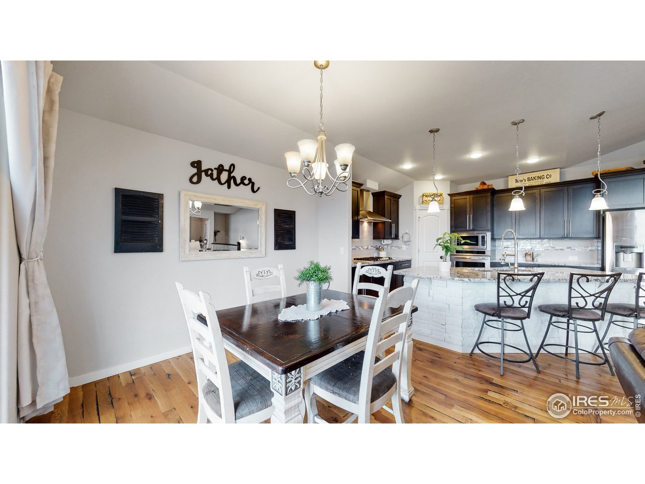 Wood floor carries to the dining room and kitchen