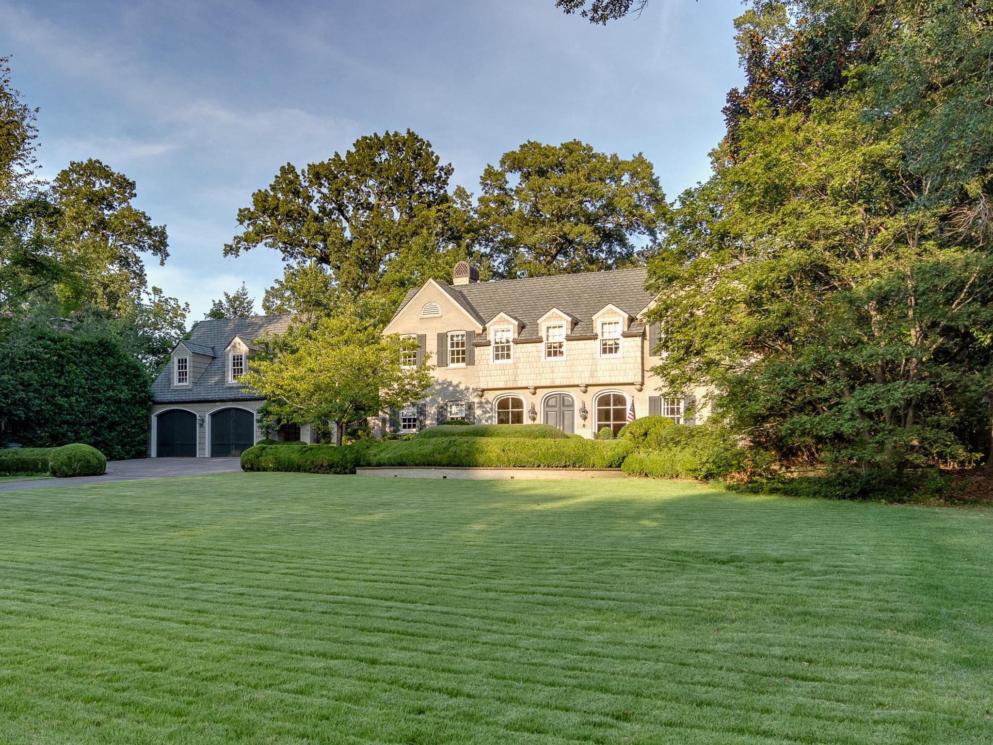 a view of house with yard and trees in the background