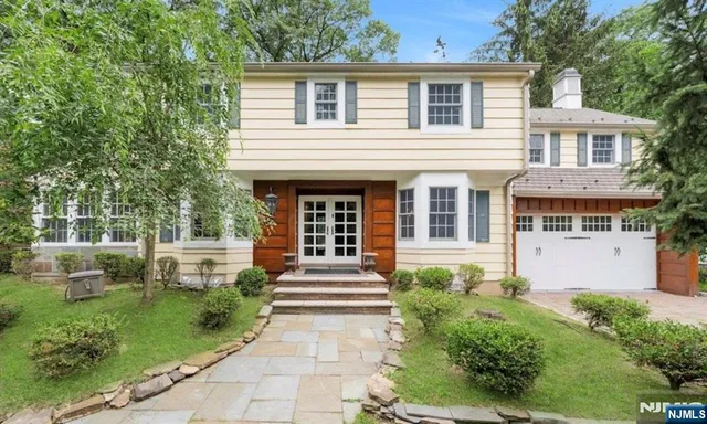 a front view of a house with a garden