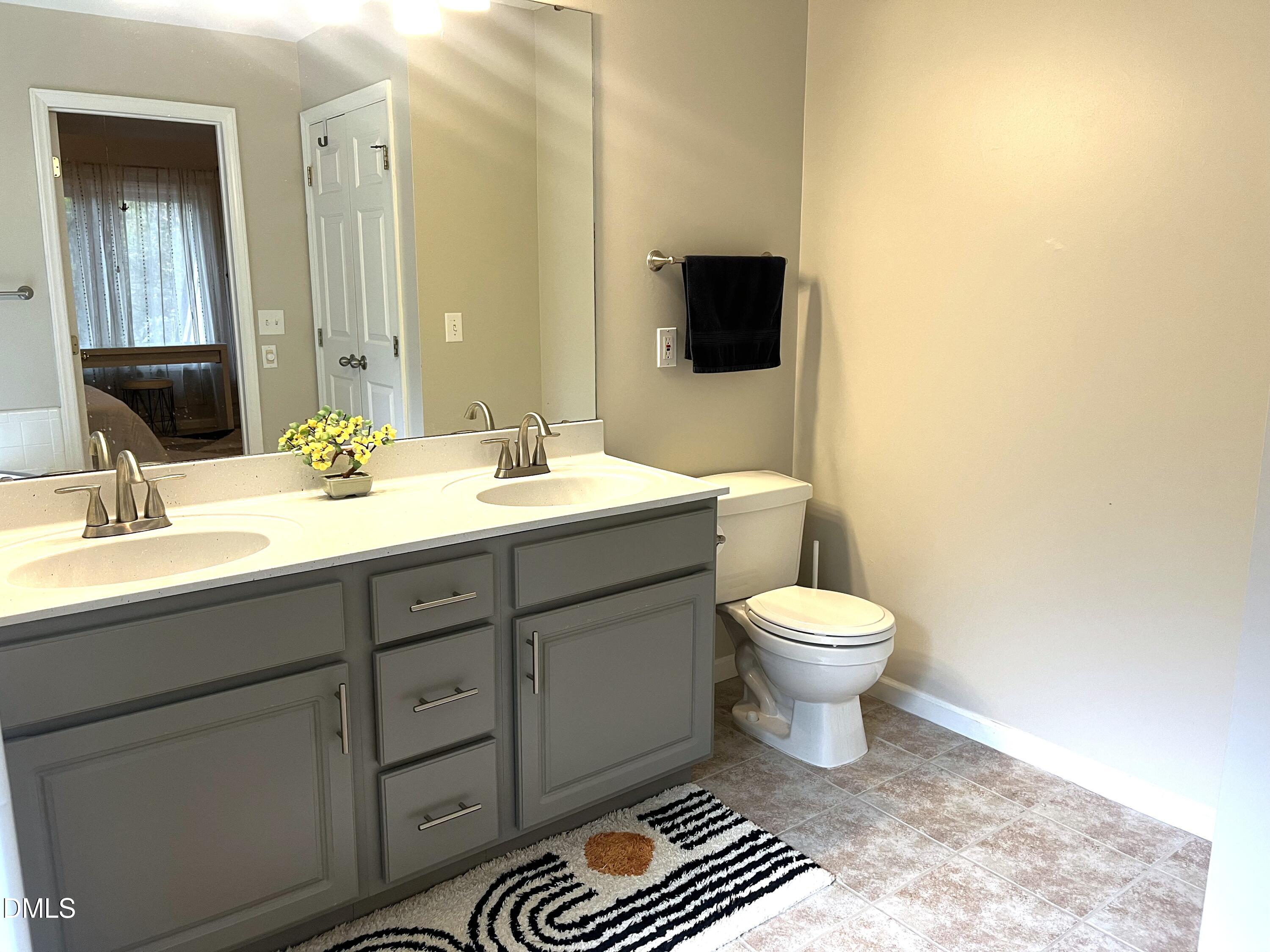 4307 Southwind Drive Raleigh, NC 27613 - Photo 11 of 15 a bathroom with a toilet a sink and mirror