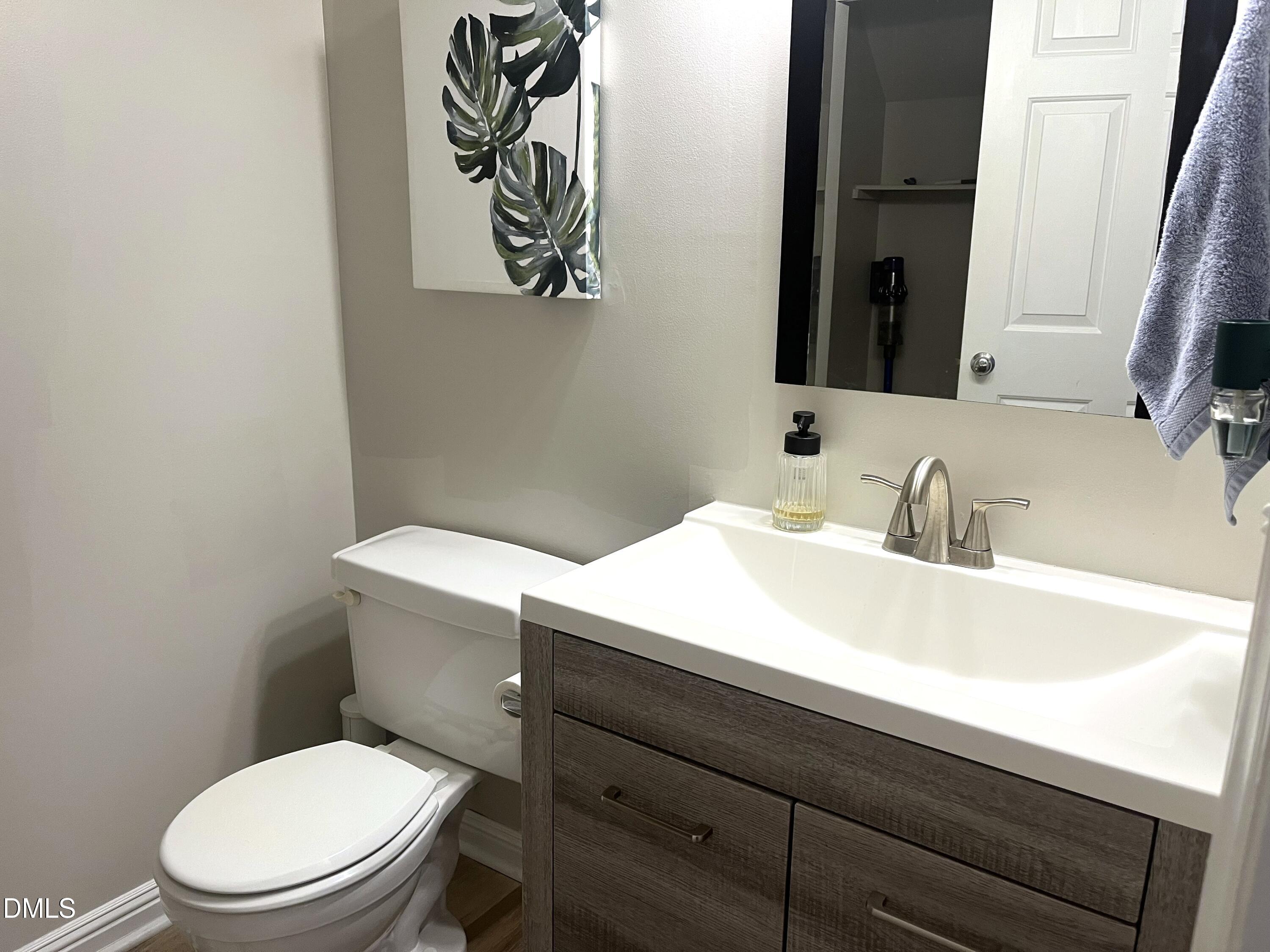 4307 Southwind Drive Raleigh, NC 27613 - Photo 14 of 15 a bathroom with a toilet a sink and mirror