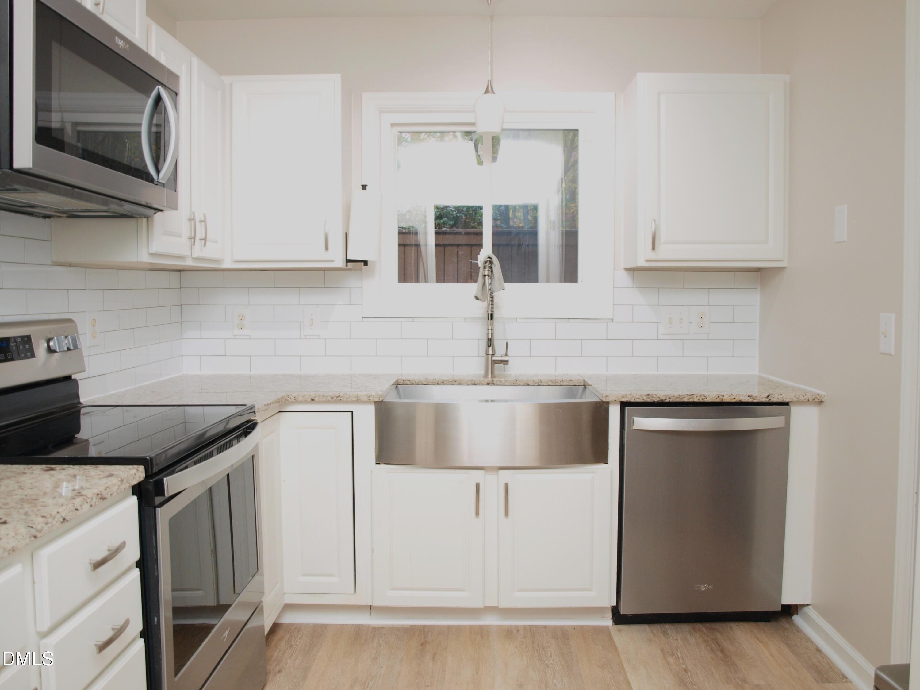 4307 Southwind Drive Raleigh, NC 27613 - Photo 6 of 15 a kitchen with stainless steel appliances granite countertop a sink and a stove