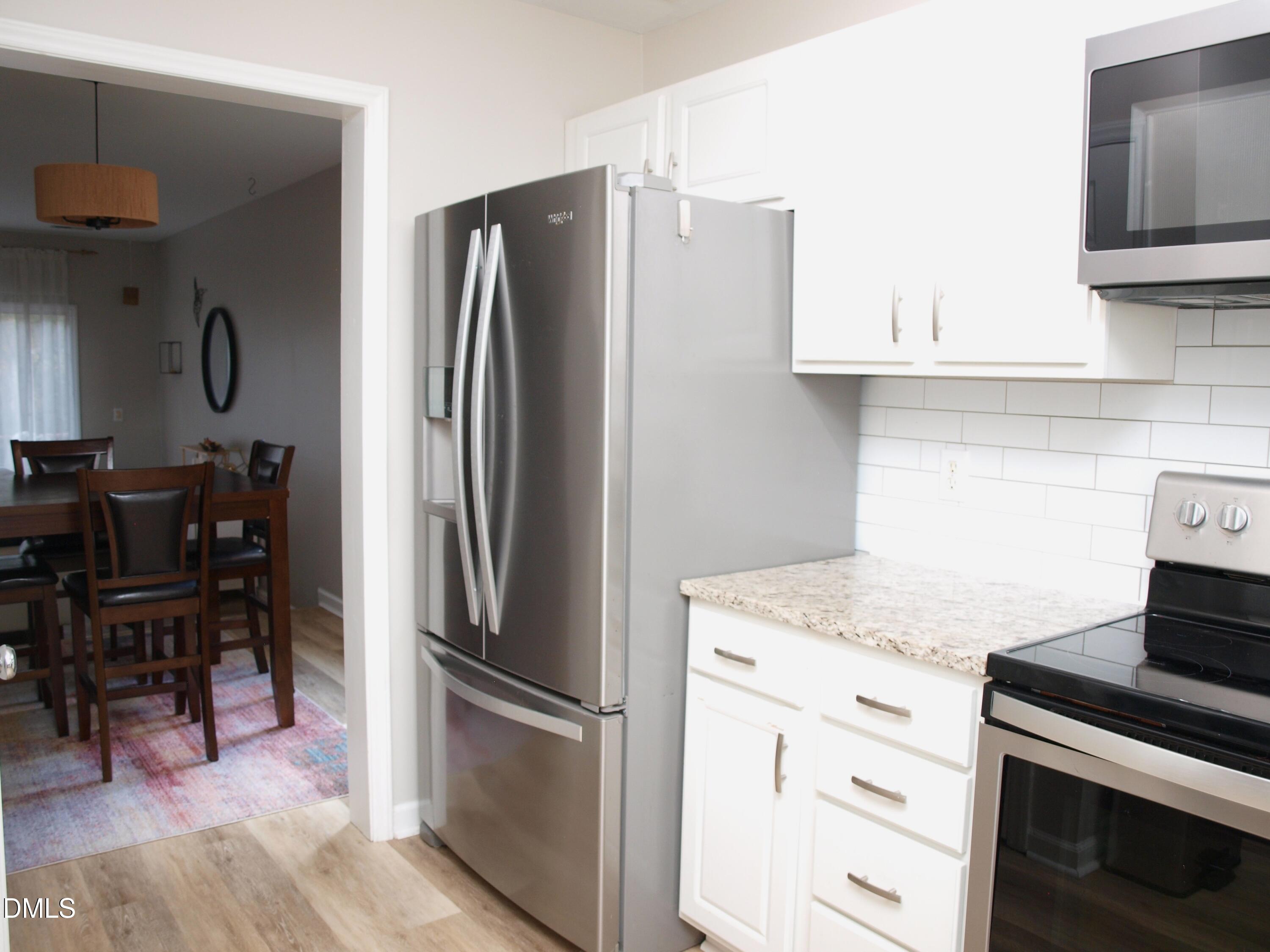 4307 Southwind Drive Raleigh, NC 27613 - Photo 8 of 15 a kitchen with stainless steel appliances granite countertop a refrigerator stove and sink