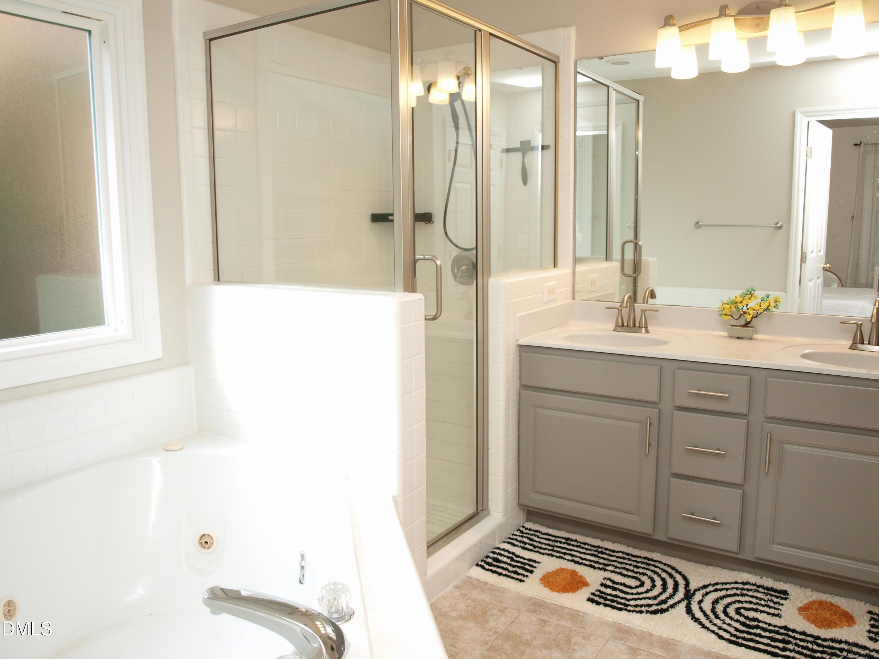 4307 Southwind Drive Raleigh, NC 27613 - Photo 10 of 15 a bathroom with a sink a mirror and a shower