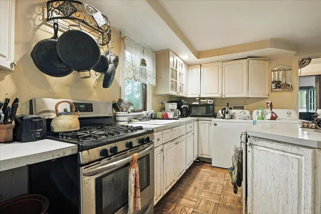 a kitchen with a sink dishwasher and a stove with wooden floor