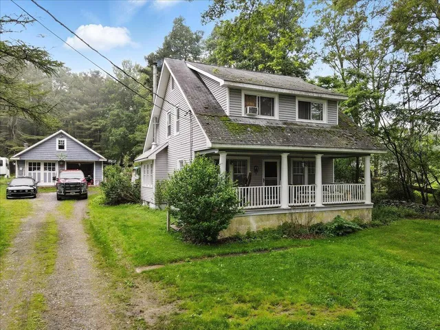 a front view of a house with yard and green space