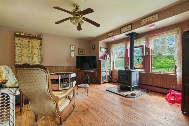 a living room with furniture a flat screen tv and a floor to ceiling window