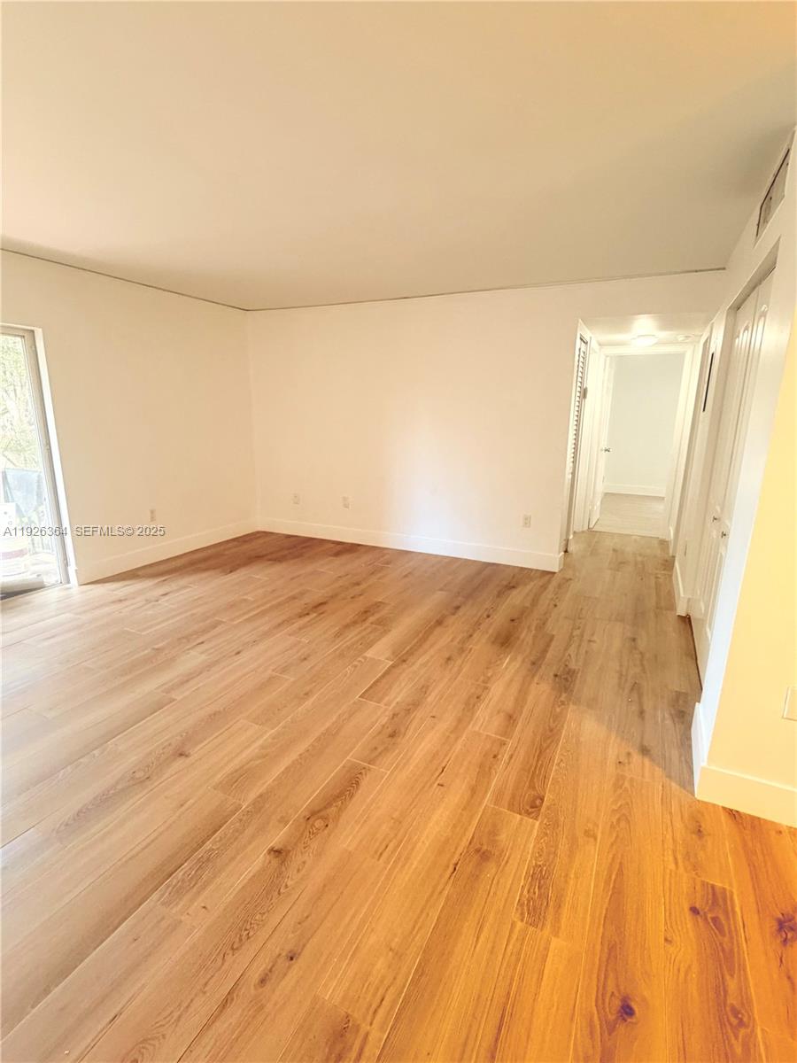 7208 Fairway Drive, Unit I20 Miami Lakes, FL 33014 - Photo 6 of 22 a view of empty room with wooden floor and fan