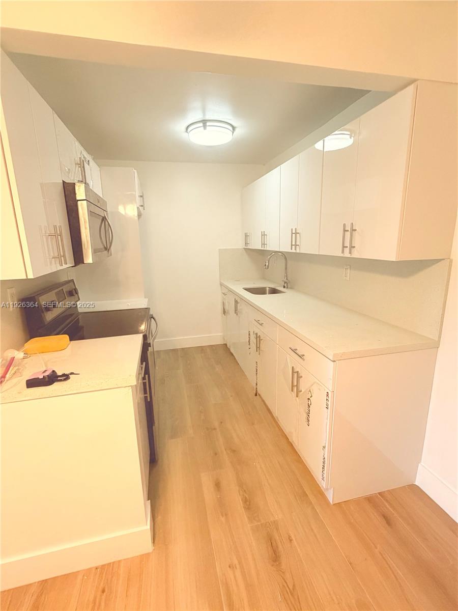 7208 Fairway Drive, Unit I20 Miami Lakes, FL 33014 - Photo 7 of 22 a kitchen with a sink a stove and a refrigerator