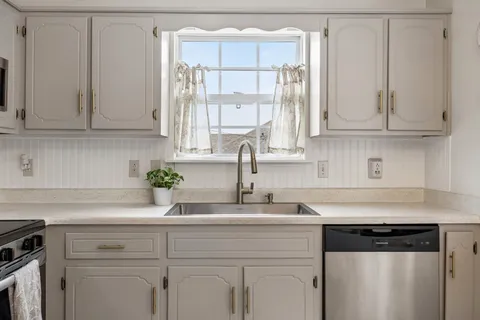 a kitchen with stainless steel appliances granite countertop white cabinets and a granite counter tops