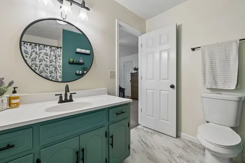 a bathroom with a toilet a sink and mirror