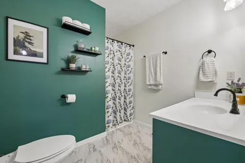 a bathroom with a sink a toilet and shower