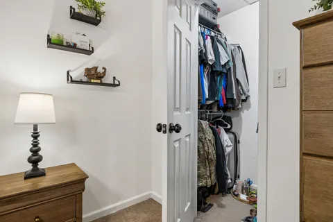 a view of walk in closet with clothes and shoes
