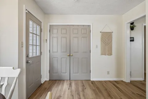 an empty room with wooden floor and a bathroom