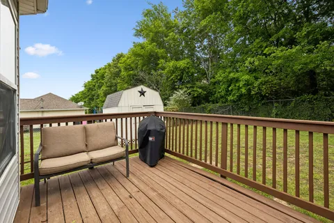 a view of balcony with wooden floor and fence