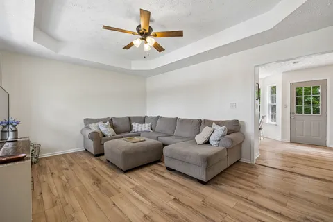 a living room with furniture and a ceiling fan
