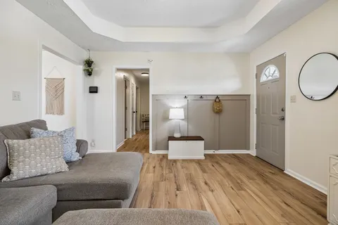 a living room with furniture and a wooden floor