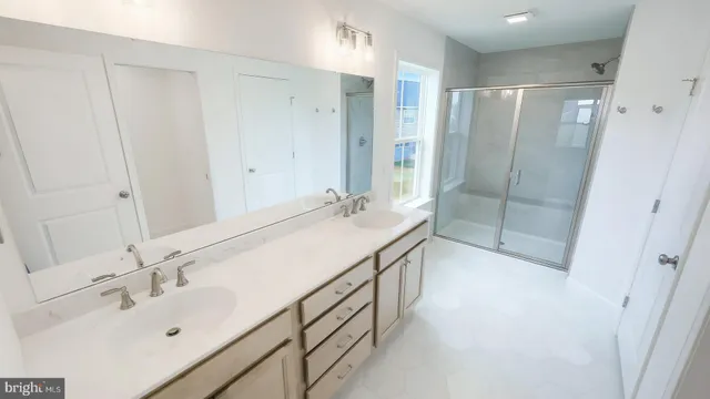 a bathroom with a shower sink and mirror
