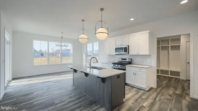 a kitchen with stainless steel appliances granite countertop a sink stove and wooden floor