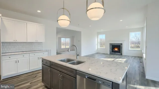a kitchen with stainless steel appliances granite countertop a sink a stove and a wooden floors