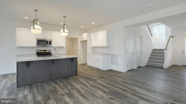 a kitchen with stainless steel appliances granite countertop a stove a sink and a refrigerator