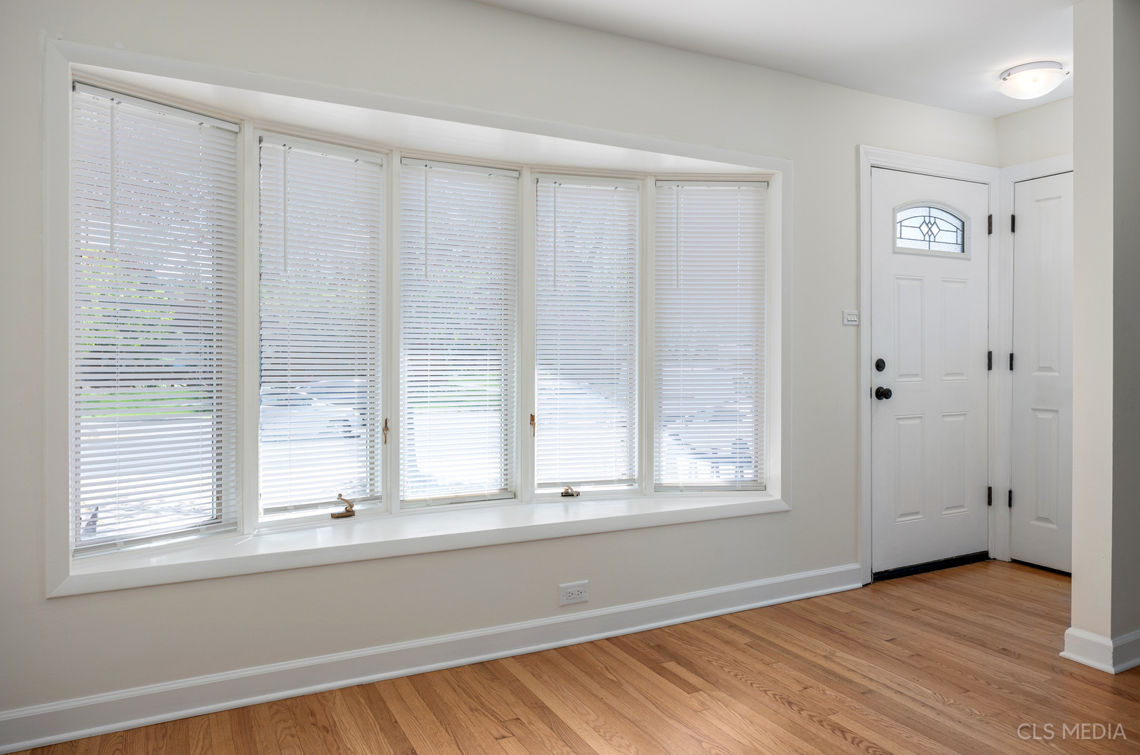 2112 Oakton Street Park Ridge, IL 60068 - Photo 3 of 24 a view of an empty room with wooden floor and a window