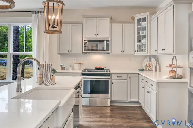 a kitchen with stainless steel appliances granite countertop a sink and cabinets with wooden floors