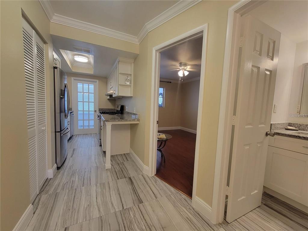 911 Washington Avenue Southwest, Unit 308 Largo, FL 33770 - Photo 11 of 24 a view of a kitchen from the hallway with a wooden floor