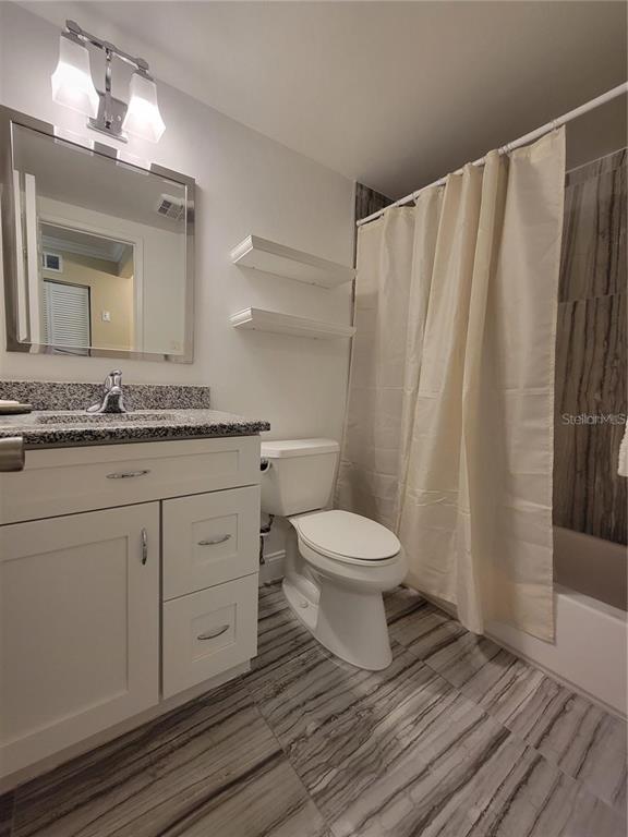 911 Washington Avenue Southwest, Unit 308 Largo, FL 33770 - Photo 16 of 24 a bathroom with a sink a toilet and shower