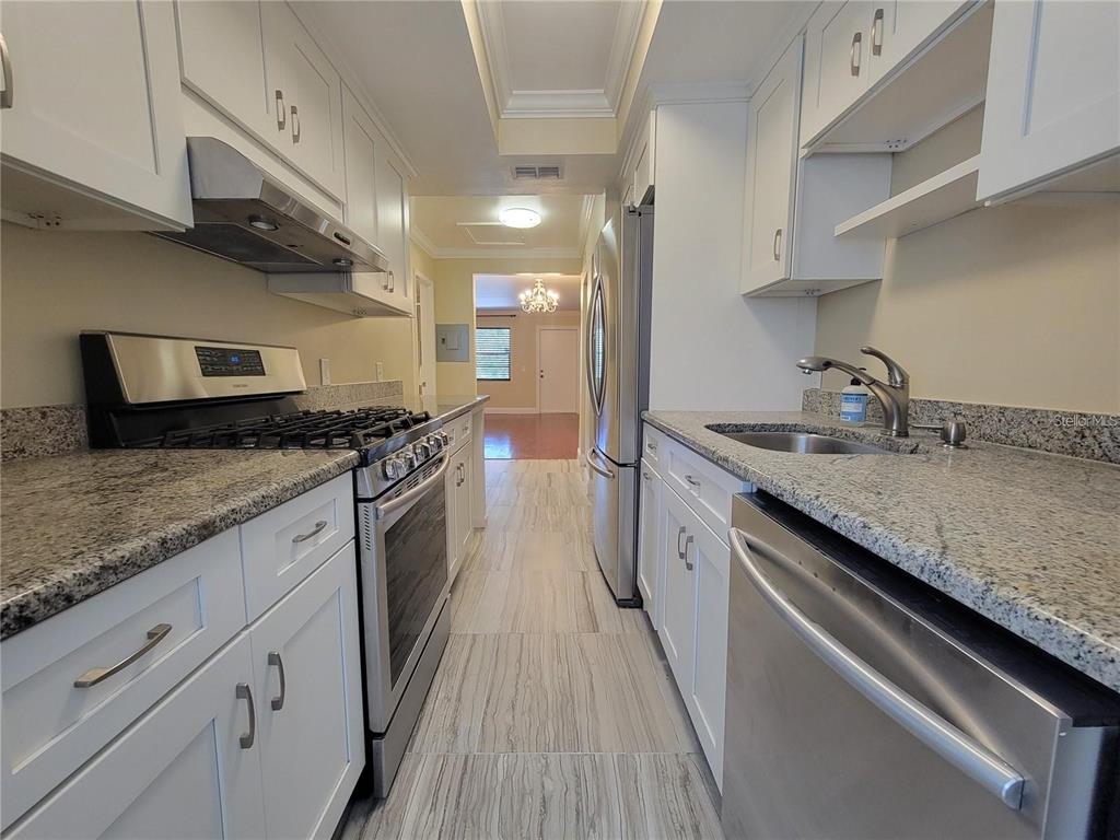 911 Washington Avenue Southwest, Unit 308 Largo, FL 33770 - Photo 4 of 24 a kitchen with granite countertop stainless steel appliances a sink stove top oven and cabinets