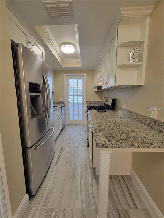 911 Washington Avenue Southwest, Unit 308 Largo, FL 33770 - Photo 6 of 24 a kitchen with granite countertop a refrigerator stove and sink