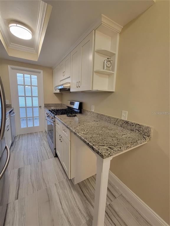 911 Washington Avenue Southwest, Unit 308 Largo, FL 33770 - Photo 7 of 24 a kitchen with stainless steel appliances granite countertop a stove sink and cabinets