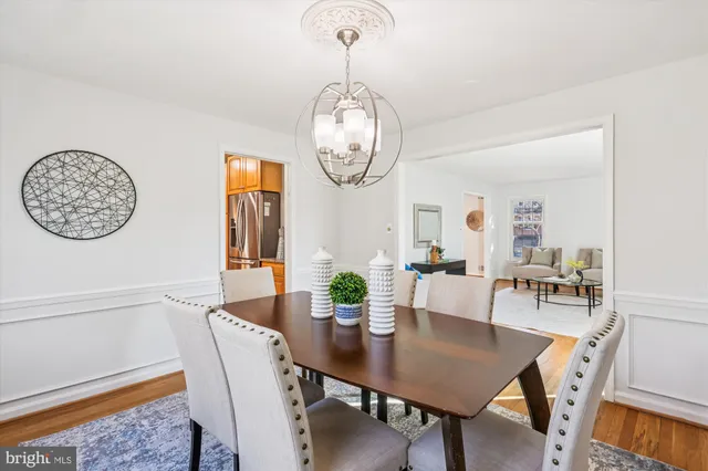 a view of a dining room with furniture a chandelier and wooden floor