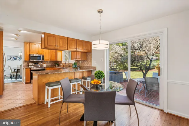 a dining room with furniture a chandelier and wooden floor