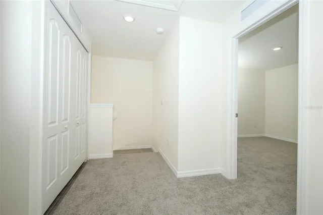 an empty room with a hallway and a bathroom