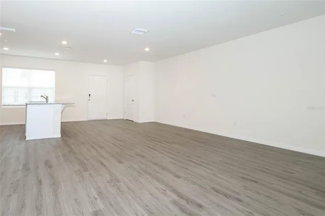 a view of a kitchen with a sink and wooden floor