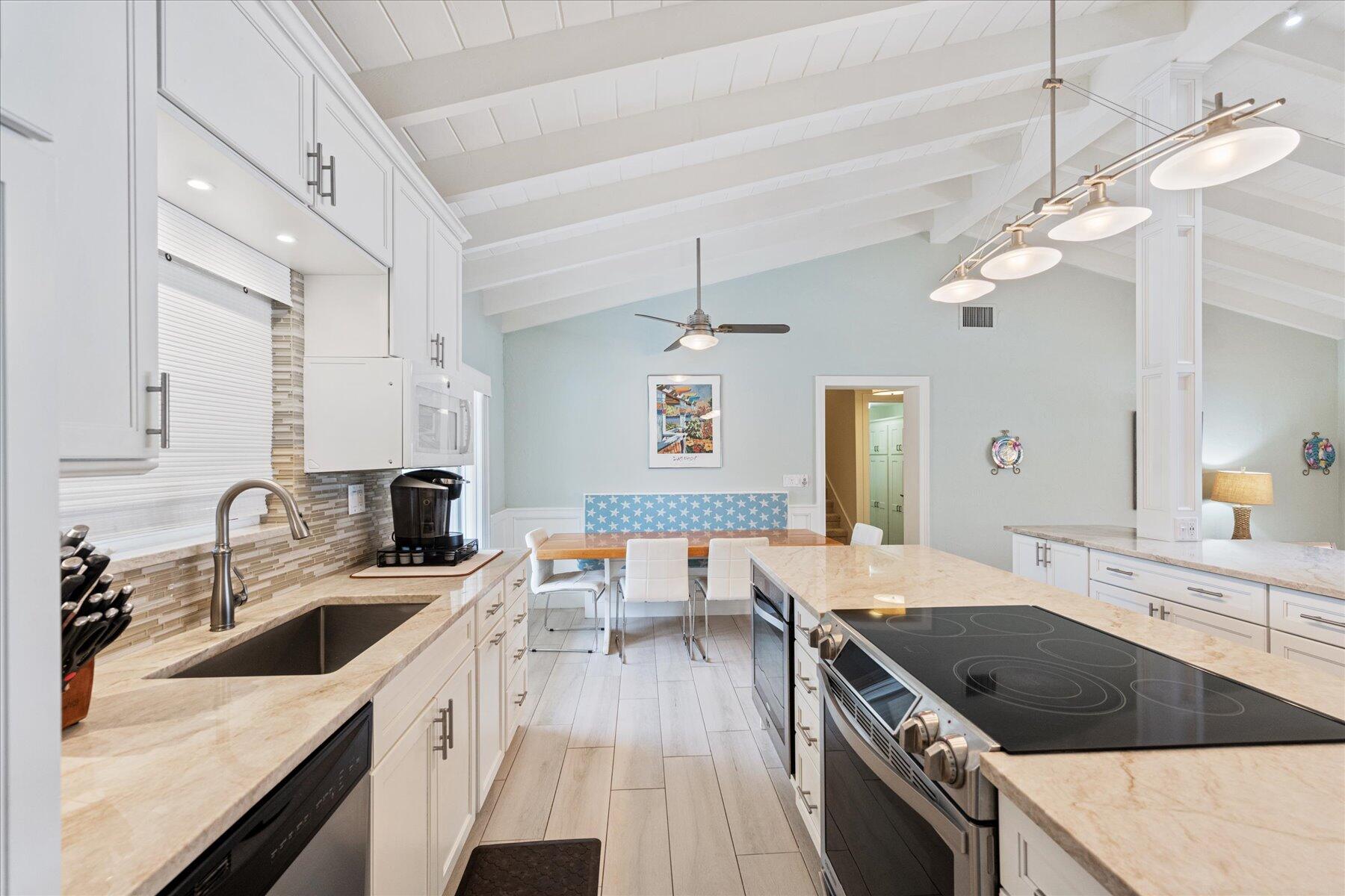 1180 Singer Drive Singer Island, FL 33404 - Photo 9 of 24 a kitchen with a sink stove and cabinets