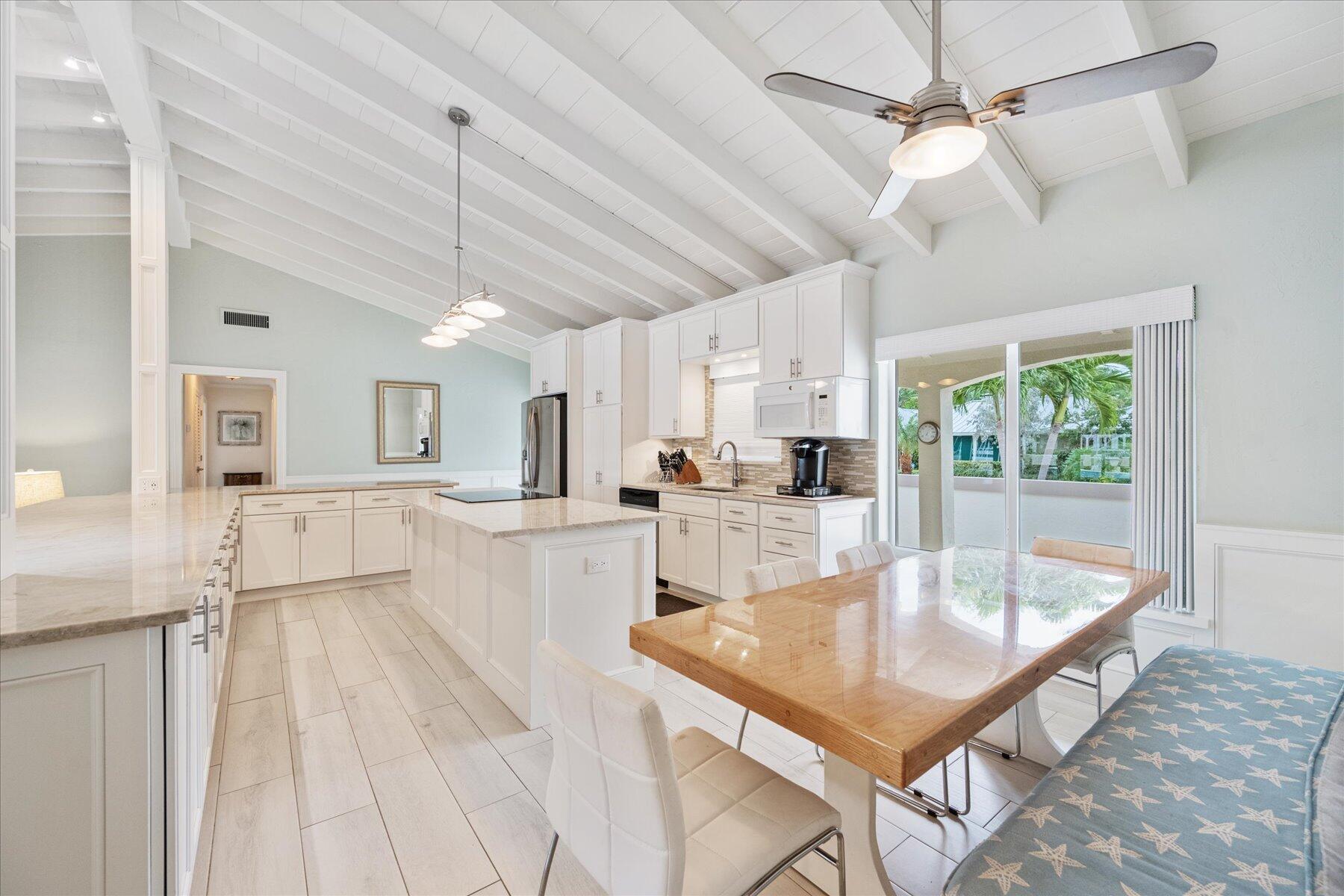 1180 Singer Drive Singer Island, FL 33404 - Photo 10 of 24 a room with kitchen island a large window a sink and cabinets