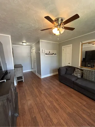 a living room with furniture and a ceiling fan