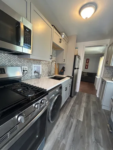 a kitchen with stainless steel appliances granite countertop a stove and a microwave