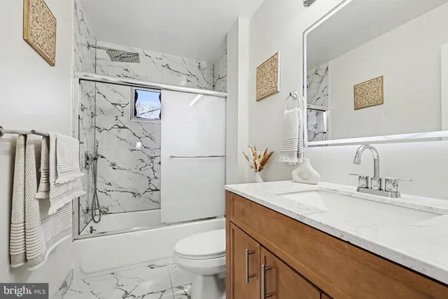 a bathroom with a sink toilet vanity and shower