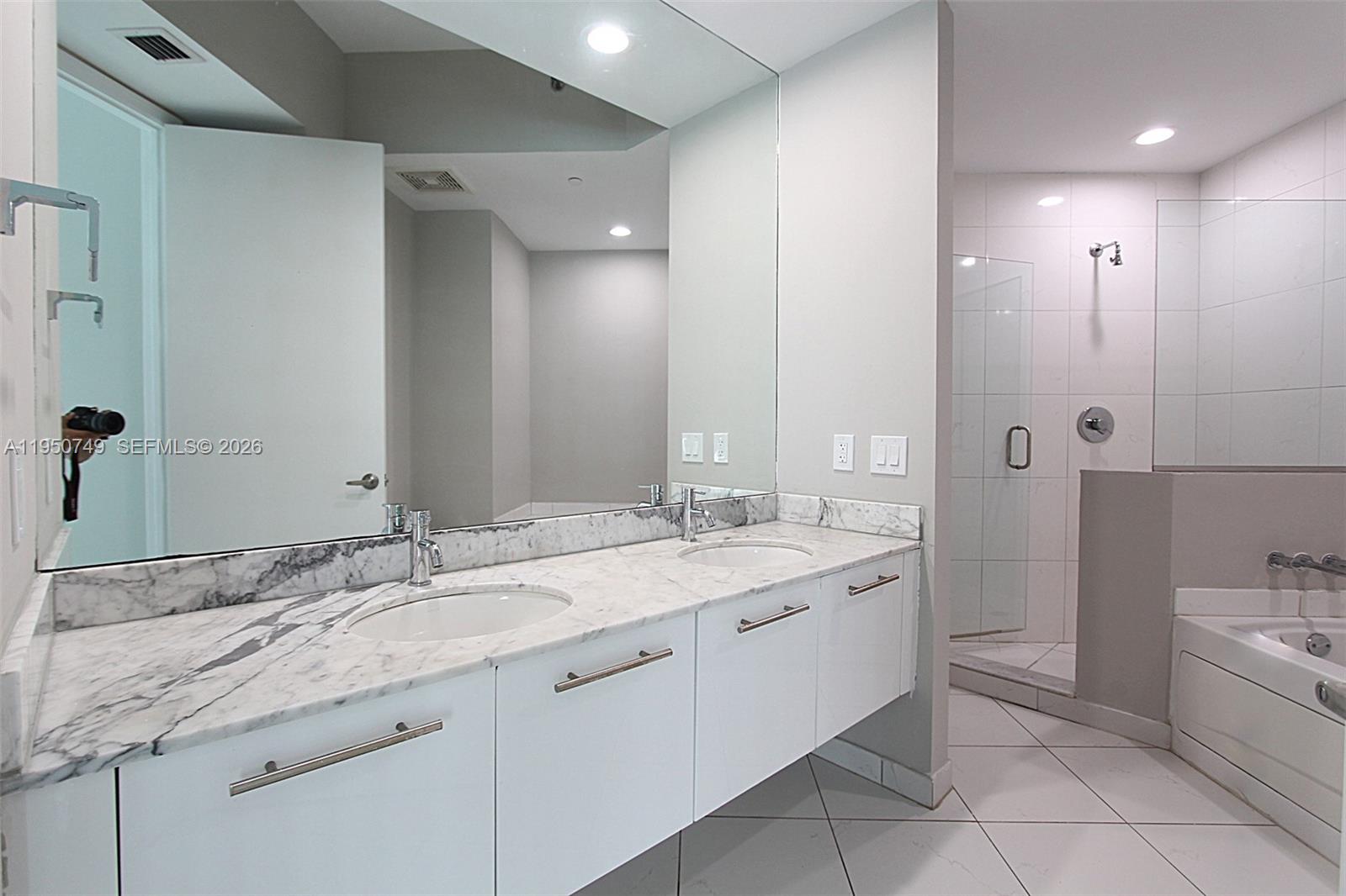 500 Brickell Avenue, Unit 4110 Miami, FL 33131 - Photo 25 of 34 a spacious bathroom with a granite countertop sink mirror and bathtub
