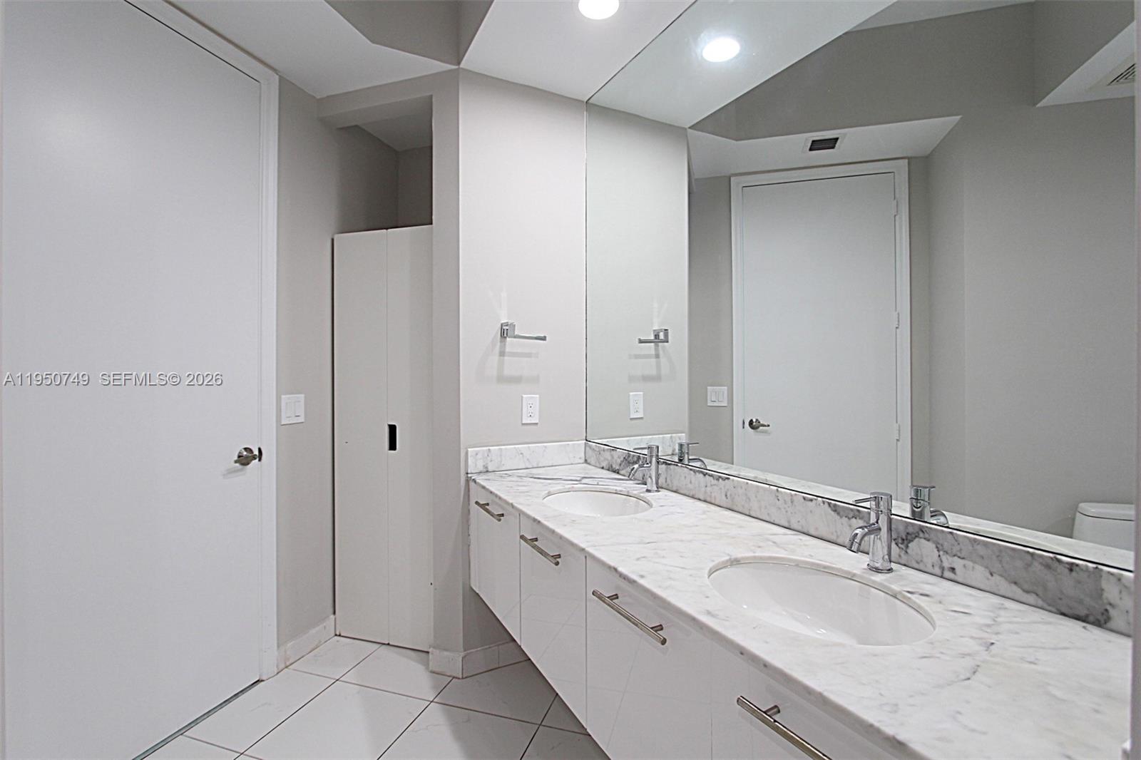 500 Brickell Avenue, Unit 4110 Miami, FL 33131 - Photo 29 of 34 a spacious bathroom with a granite countertop sink and a mirror